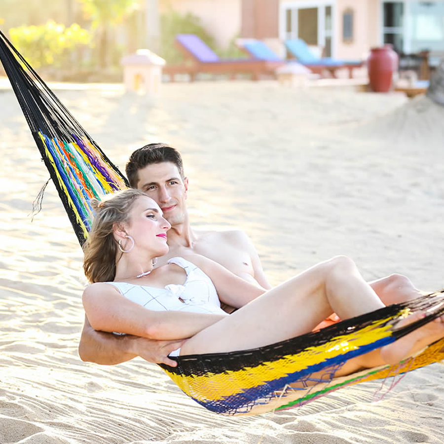Couple relaxing together in a hammock by the sea