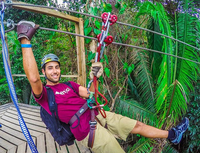 Guest wearing a helmet and harness on a Belize jungle zipline