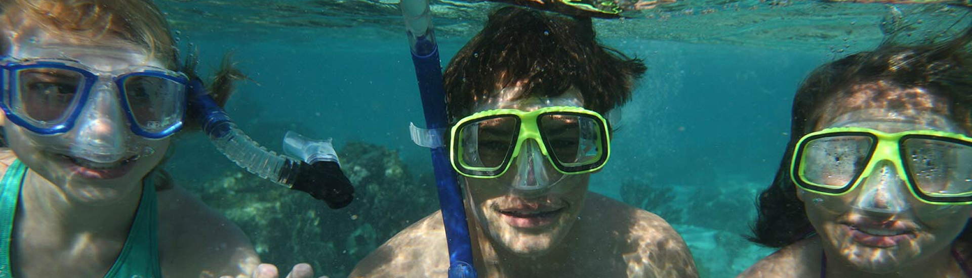 Guests wearing masks and snorkels underwater in Belize