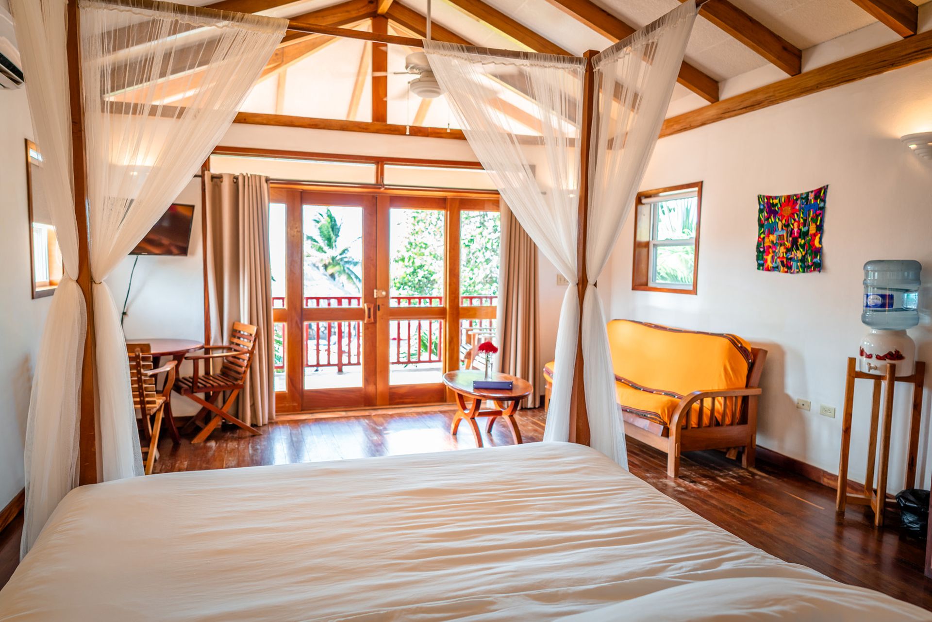 Four-poster bedroom with white linens at Belizean Dreams