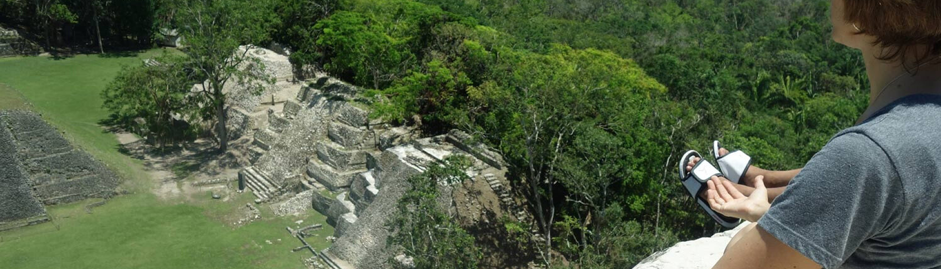 Traveler overlooking Maya ruins surrounded by jungle in Belize