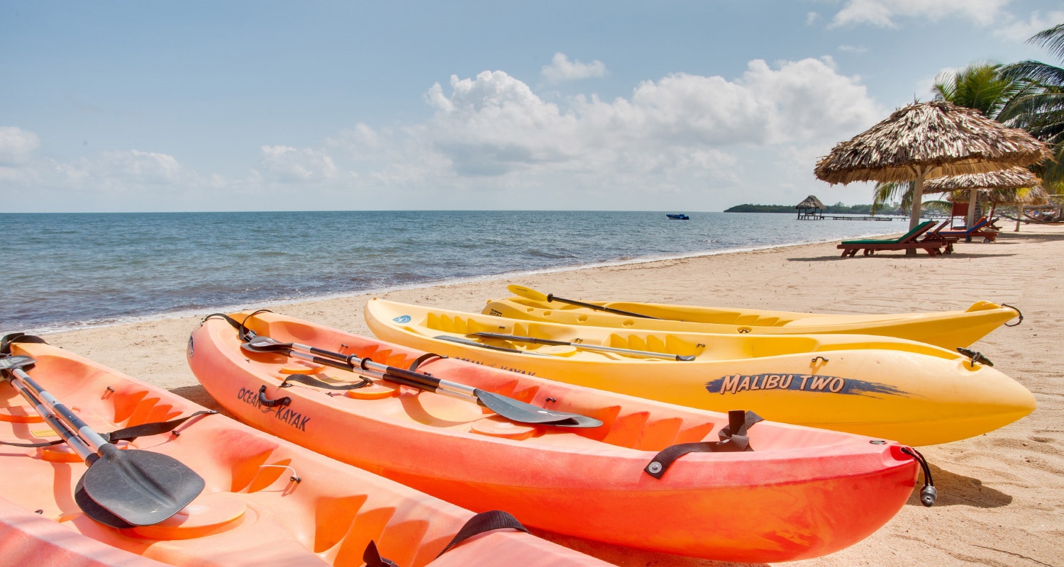 Orange and yellow kayaks on the Belizean Dreams beach