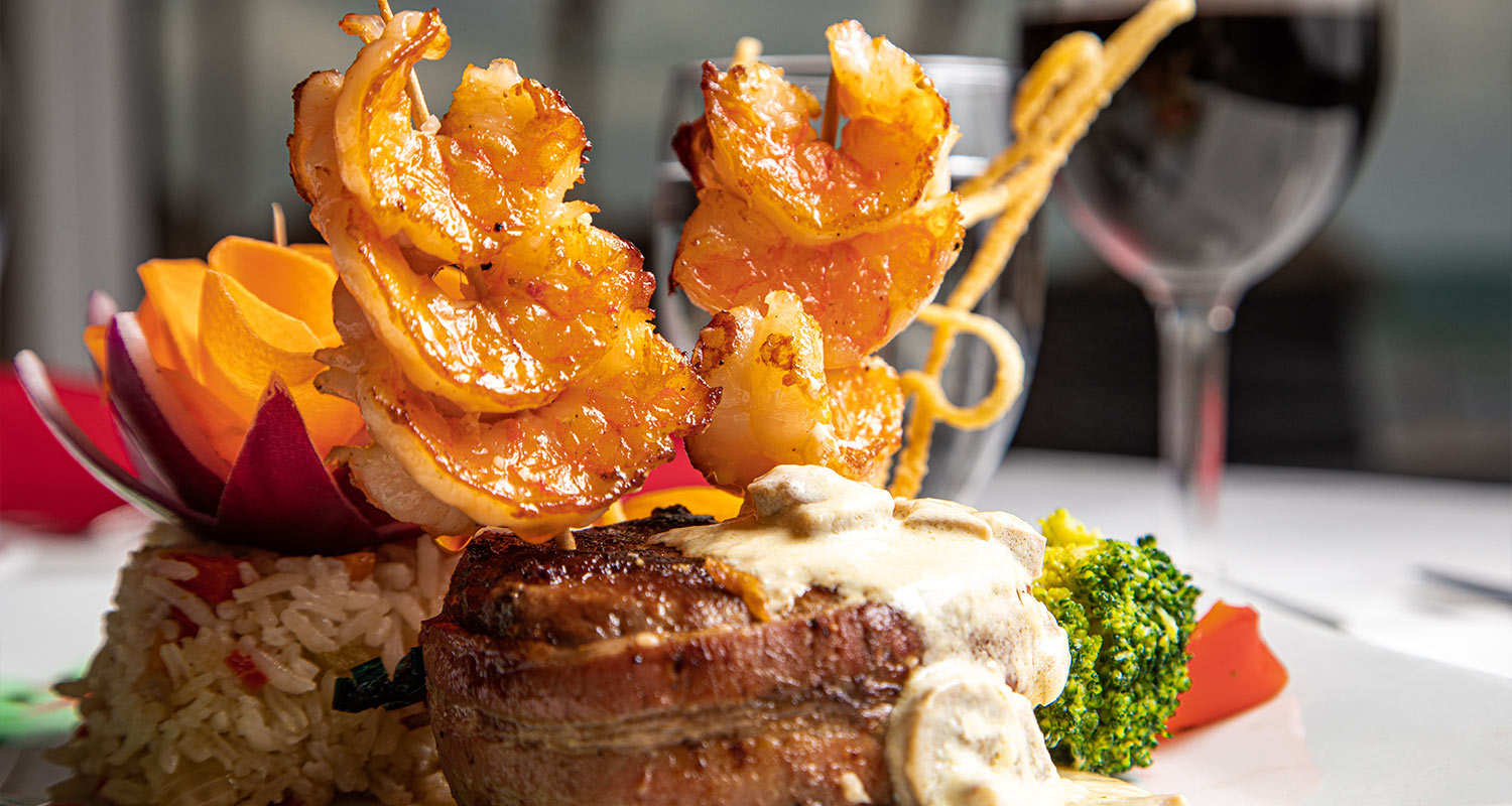 A plated steak and shrimp meal at the Woven Palms Restaurant