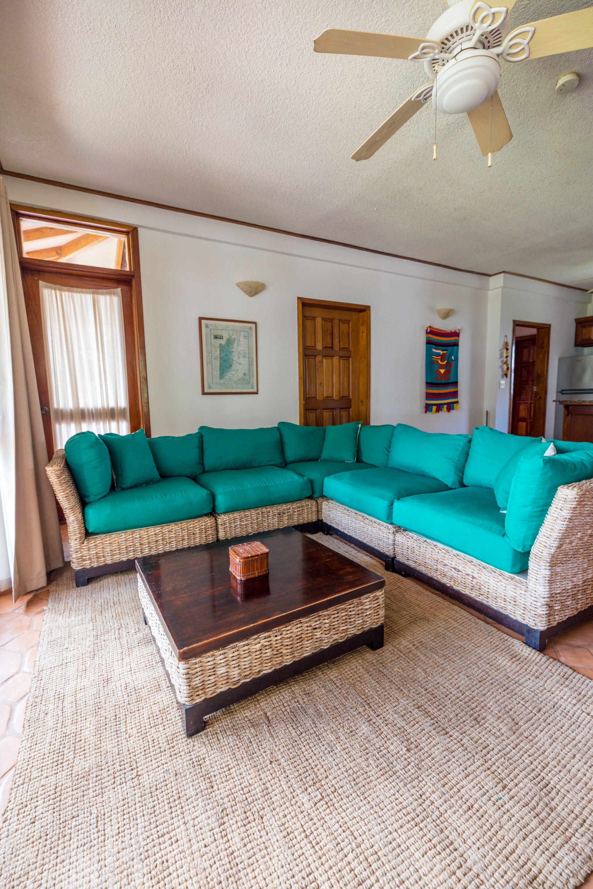 Villa living and dining area with a teal sofa at Belizean Dreams