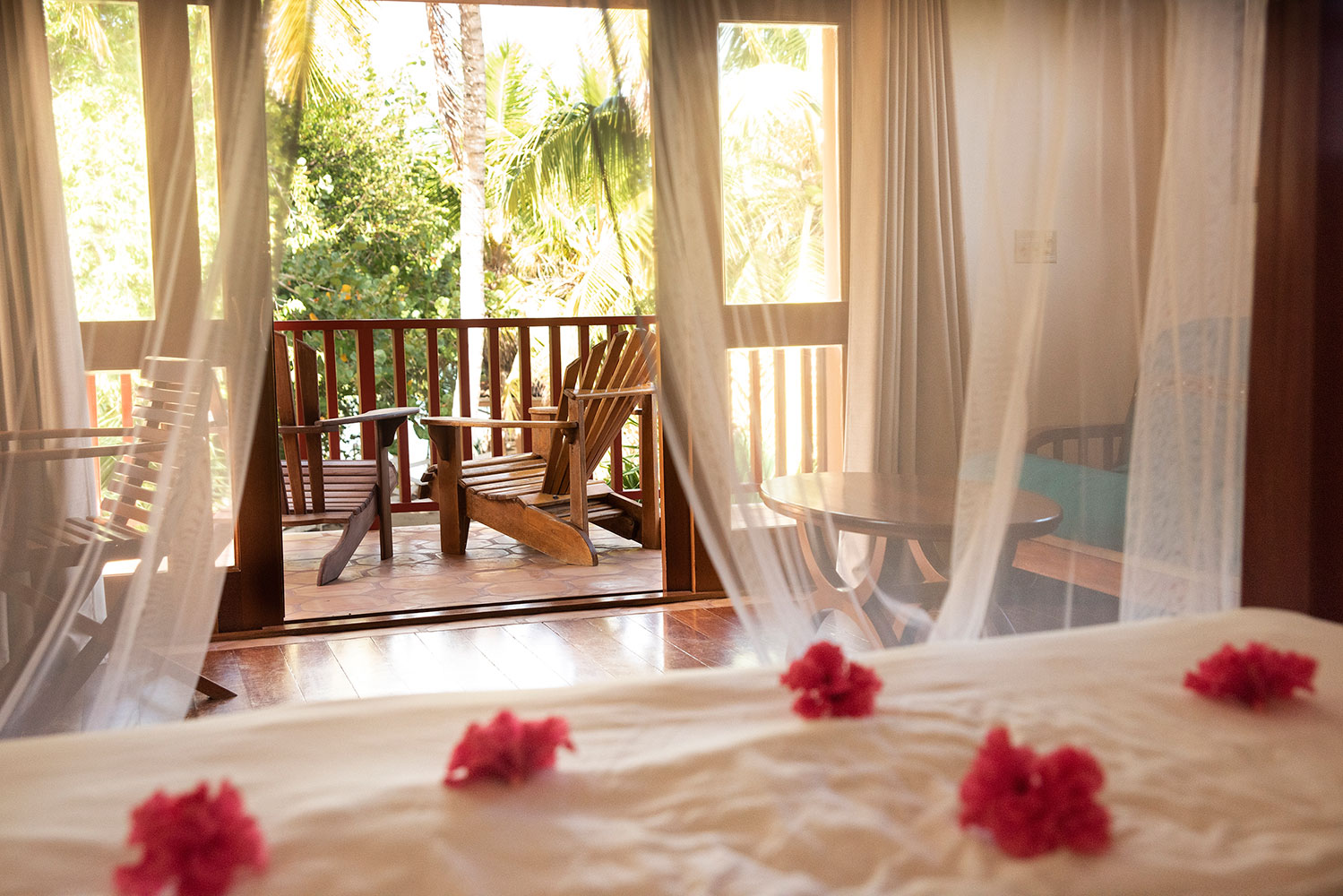 Belizean Dreams bedroom with flowers and a balcony beyond