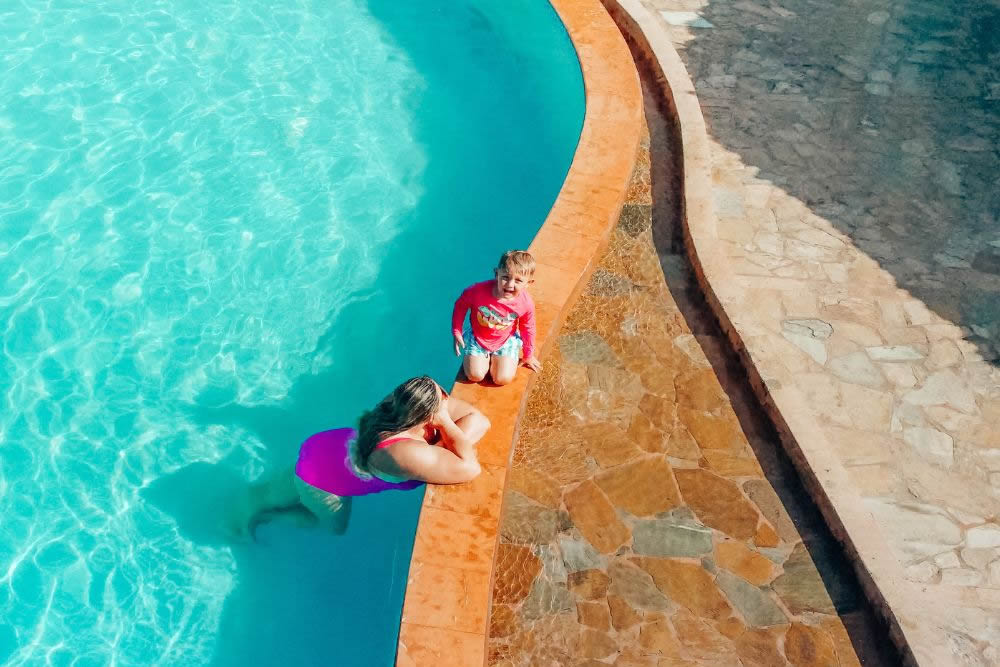 A parent and child spending time beside the resort’s infinity pool