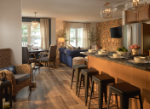 A modern kitchen and dining area featuring a bar counter, seating, and stylish decor.