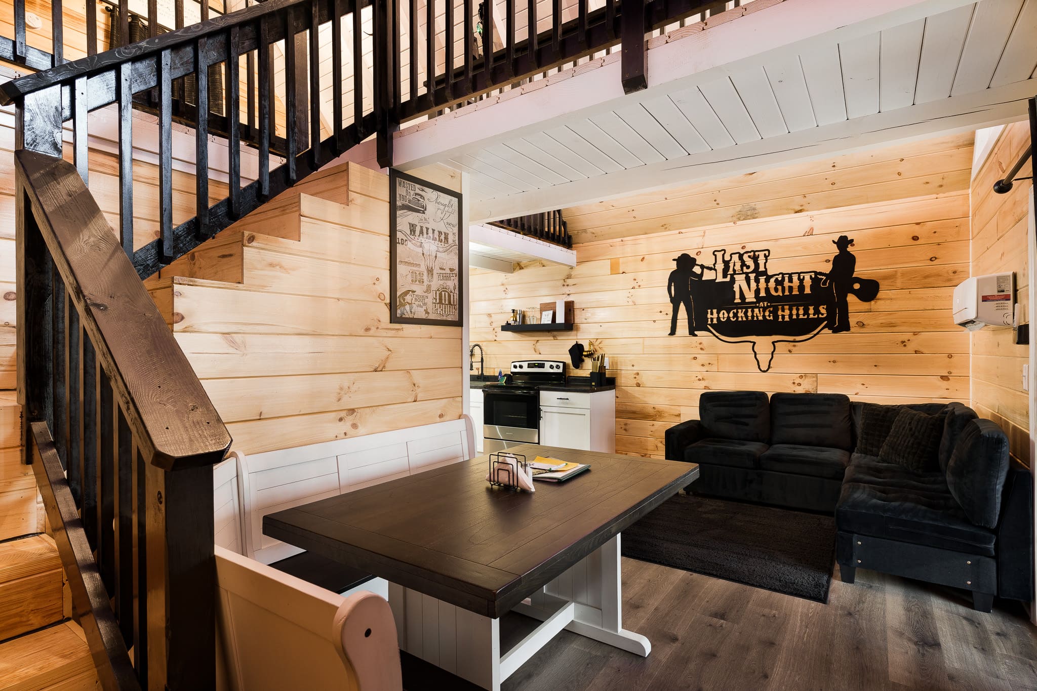 Cozy wood-paneled interior featuring a dining table, kitchenette, and seating area.