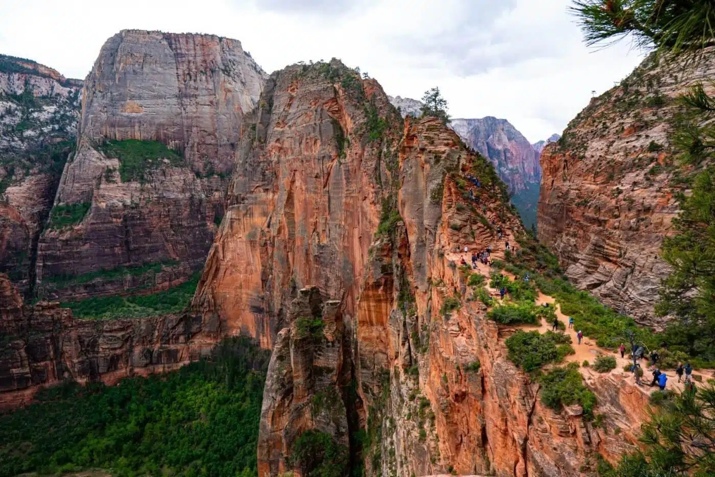 Image of rugged canyon cliffs under a cloudy sky.