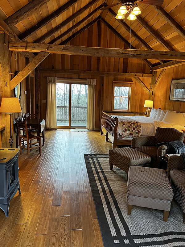 Picture showing the inside of St. Mary's Cabin with a king bed, 2 cushioned chairs, a propane fireplace, and a small table with 2 chairs Picture showing the inside of St. Mary's Cabin with a king bed, 2 cushioned chairs, a propane fireplace, and a small table with 2 chairs