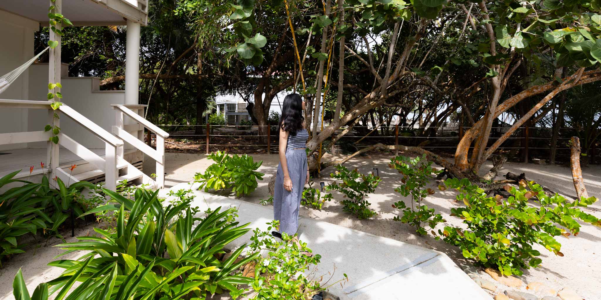 A guest walking outside of their pool view room at Blue Reef Beach Resort in Placencia Belize