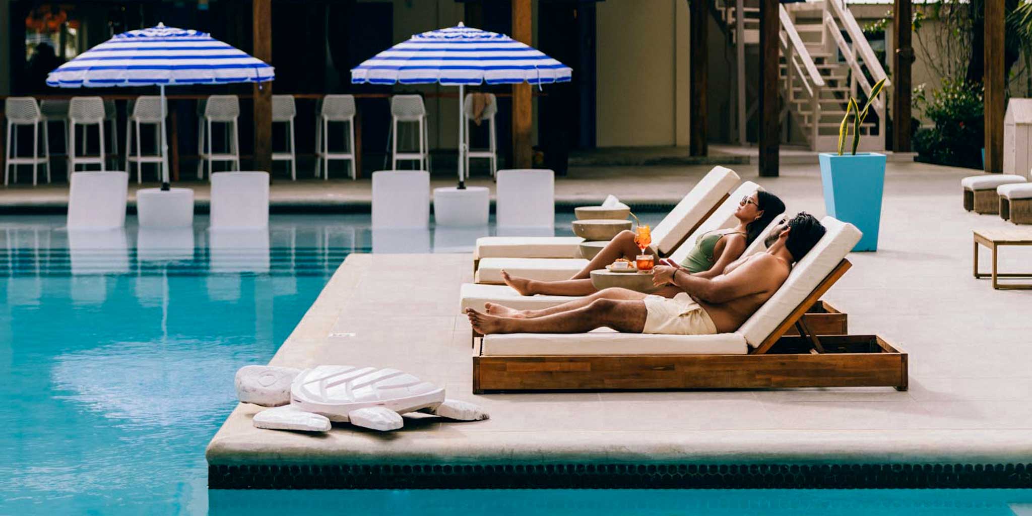A couple relaxing by the poolside at Blue Reef Beach Resort on the Placencia Peninsula in Belize