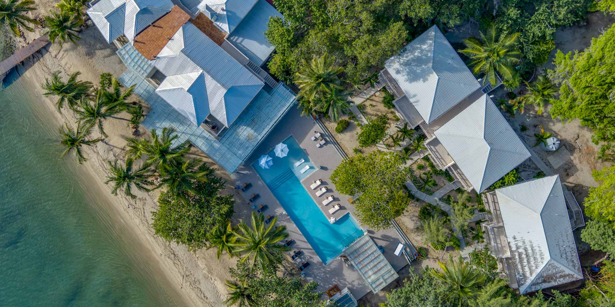 Aerial view of the suites and the pool surrounded by greenery at Blue Reef Beach Resort in Placencia