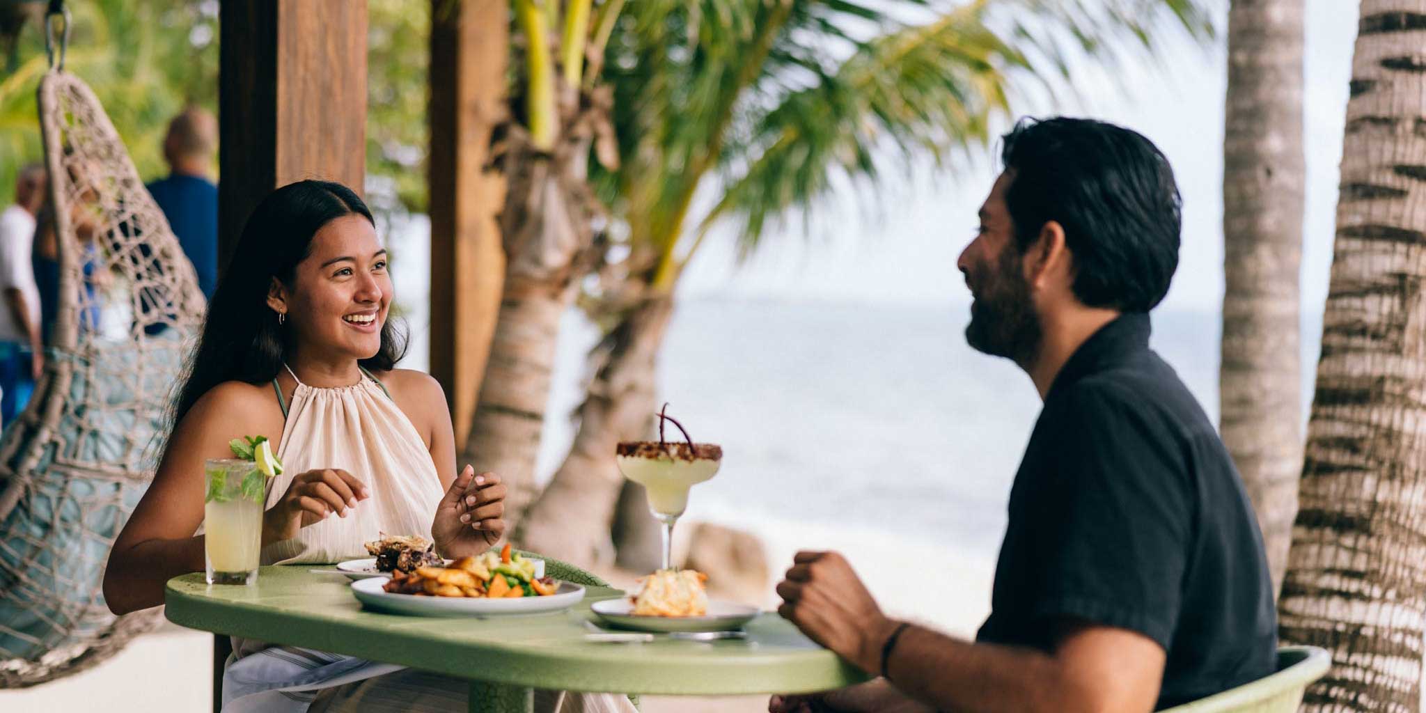 A couple having lunch at Bamboo Beach Bistro at Blue Reef Beach & Marina in Placencia